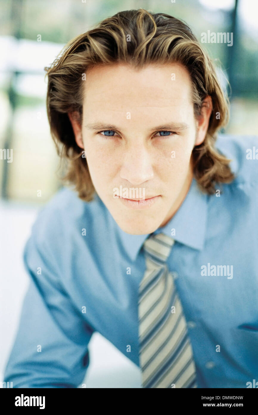 Un giovane uomo con parentesi marrone capelli indossa una camicia blu e cravatta. Foto Stock