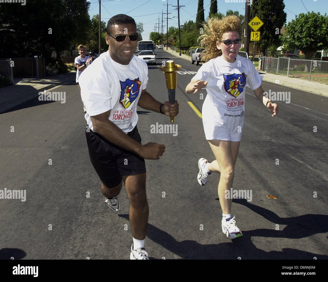 Jun 23, 2001; Oakley, CA, Stati Uniti d'America; California Highway Patrol officer Reggie Gayles prende la torcia da Brentwood del dipartimento di polizia di servizio comunitario Officer Michele Keady su O'Hara Avenue di Oakley, California, martedì 5 giugno 2001. Gayles correva attraverso Oakley con un contingente di ufficiali della CHP e il Contra Costa dello sceriffo della contea di reparto in applicazione della legge fiaccolata per Foto Stock