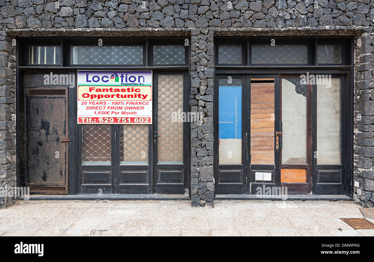 Negozio chiuso con in vendita segno sul fronte mare nel centro di Costa Teguise, Lanzarote, Isole Canarie, Spagna Foto Stock