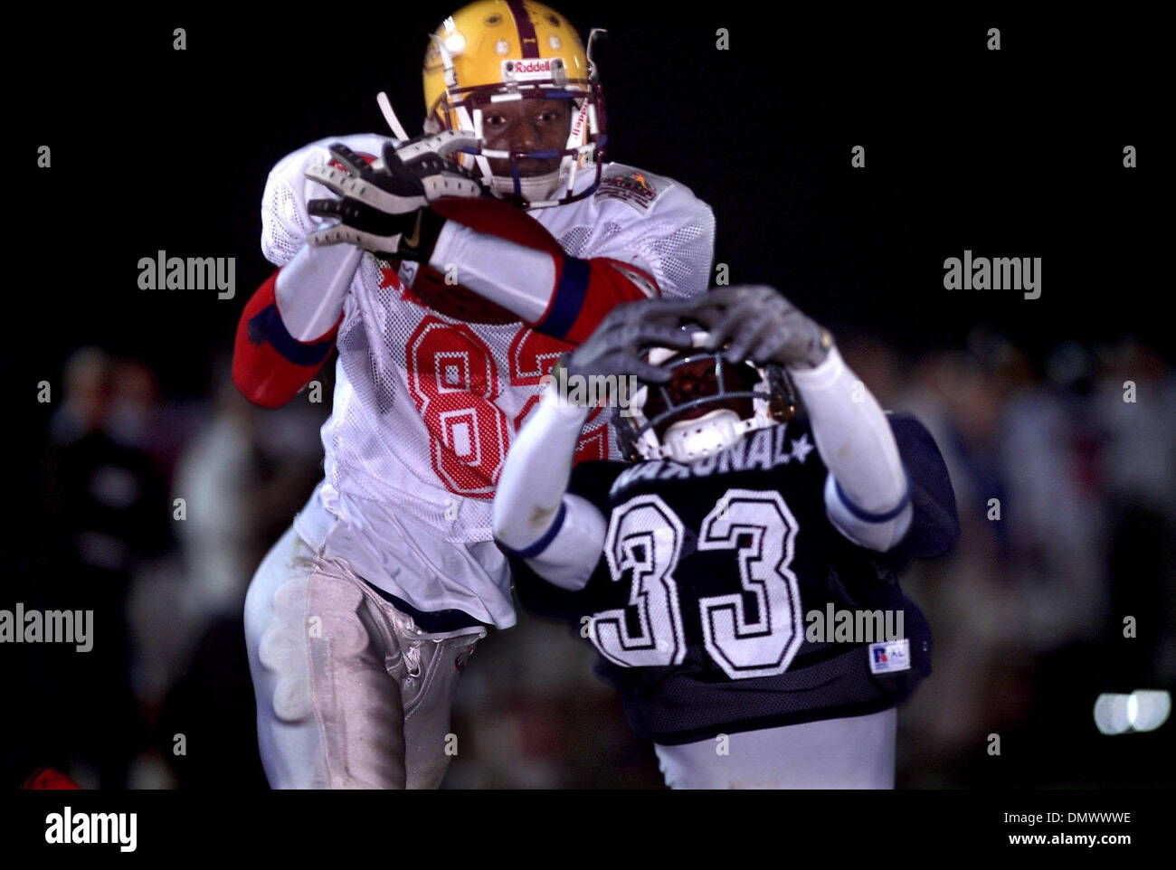 Jan 12, 2002 - Palm Beach Gardens, Florida, Stati Uniti d'America - Durante la prima metà azione alla ottava edizione Outback Steakhouse di alta scuola All-Star gioco di calcio a William Dwyer High School, American team player SANTONIO HOLMES di radure Central High School cale in un pass per un touchdown mentre vengono difesi dalla squadra nazionale stati DEMETRIO HODGES del Cardinale Newman di alta scuola. (Credito Imag Foto Stock