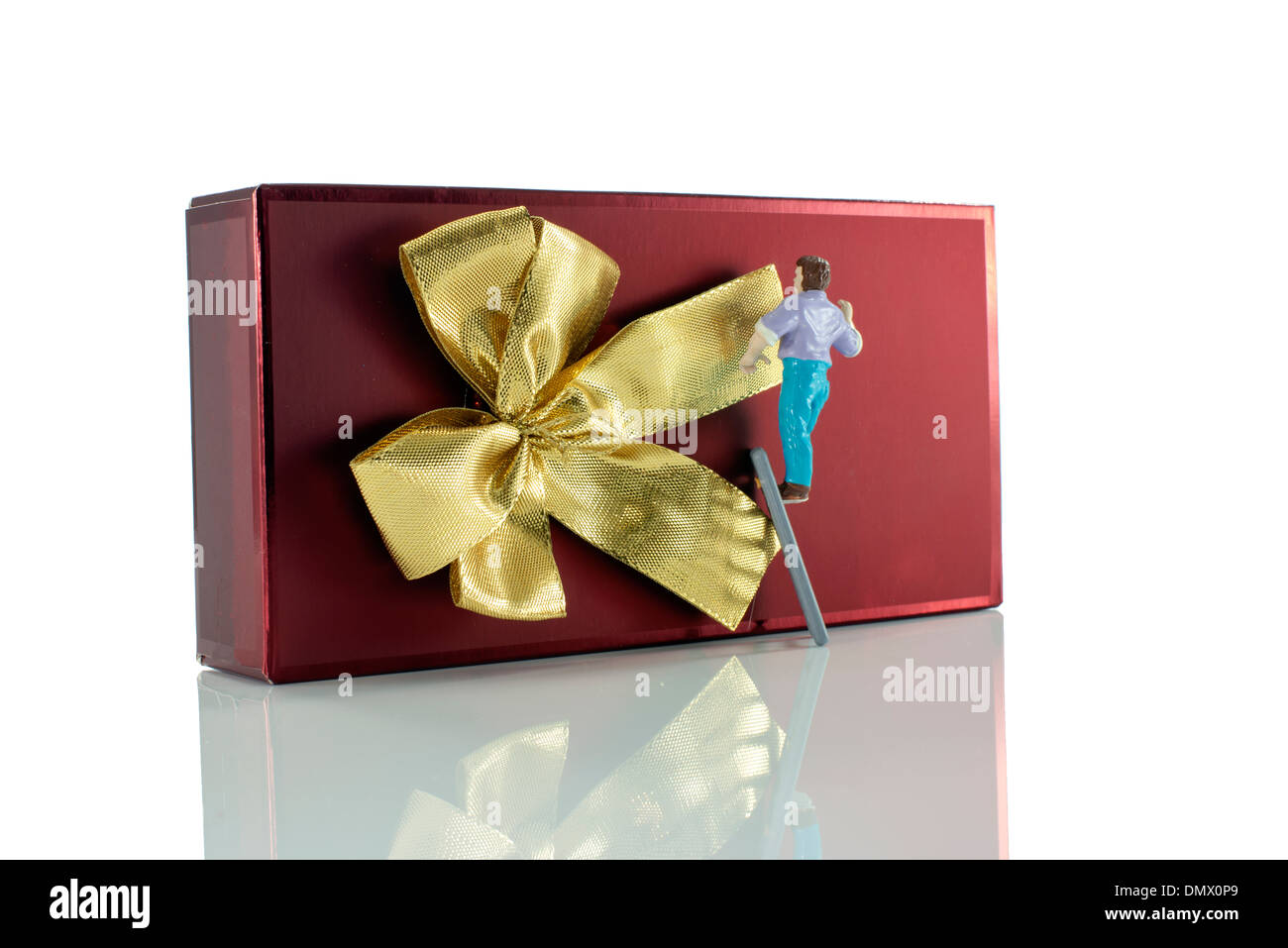Puppet uomo rendendo il golden bow sul rosso regalo di natale Foto Stock