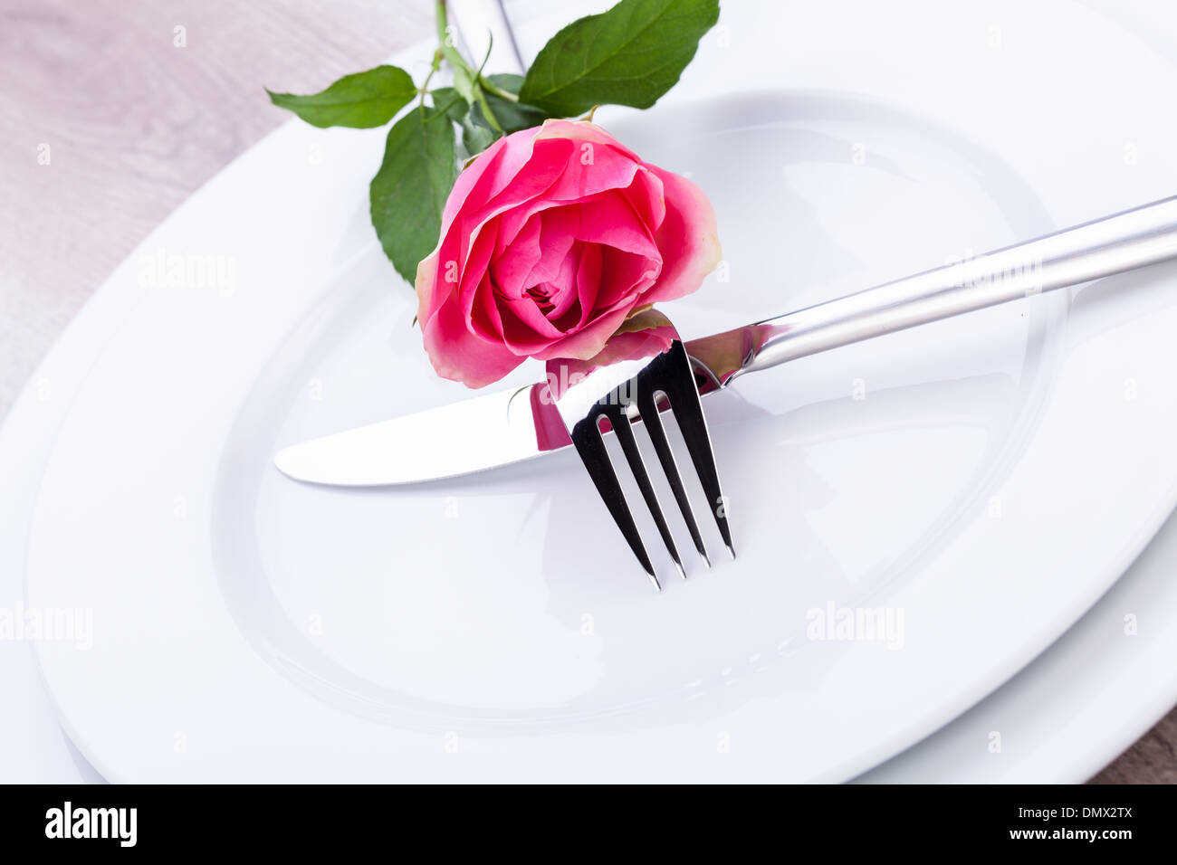 Romantico elegante formale messa in tavola con una sola rosa rosa e nastro decorativo per un innamorato il giorno di San Valentino Foto Stock