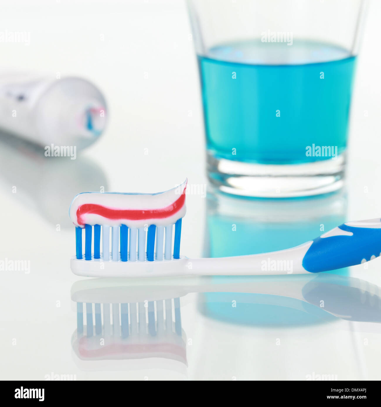 Igiene dentale con un dentifricio sullo spazzolino e risciacquare Foto Stock