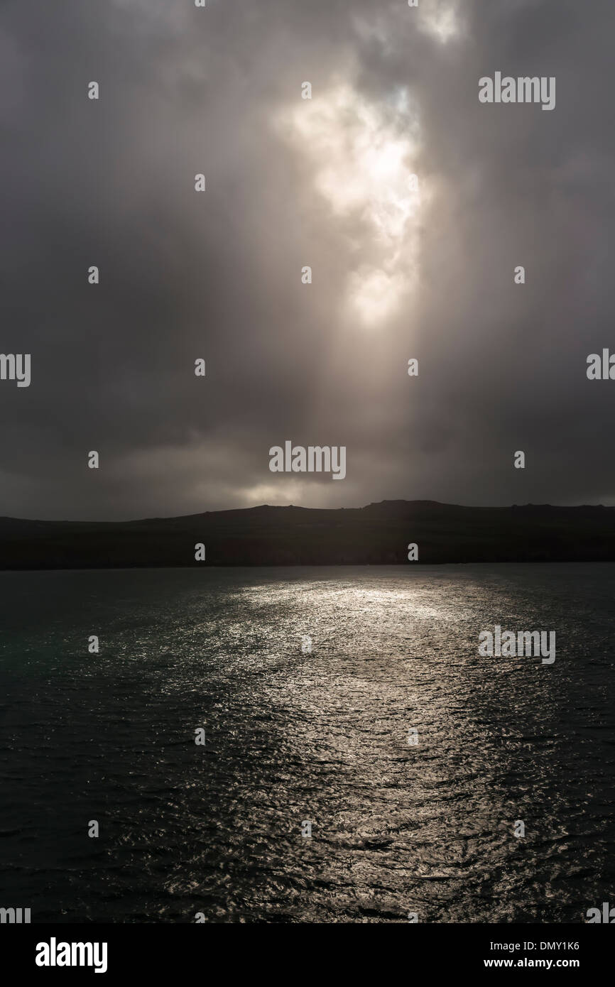 I raggi di sole shinging attraverso una pausa tra le nuvole al largo delle coste del Galles occidentale vicino a Fishguard, REGNO UNITO Foto Stock
