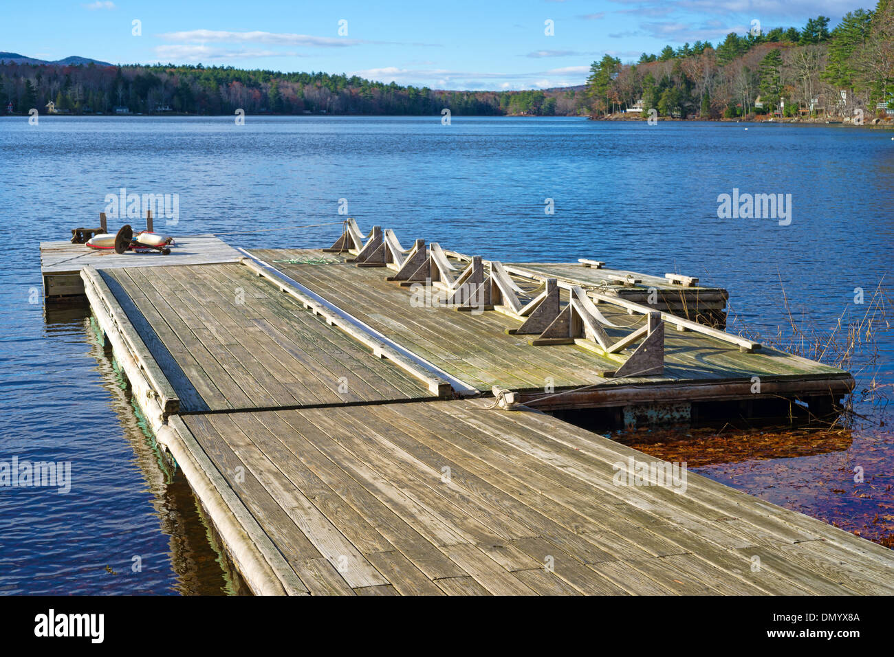 Un legno pontile galleggiante che si estende su un piccolo lago. Foto Stock