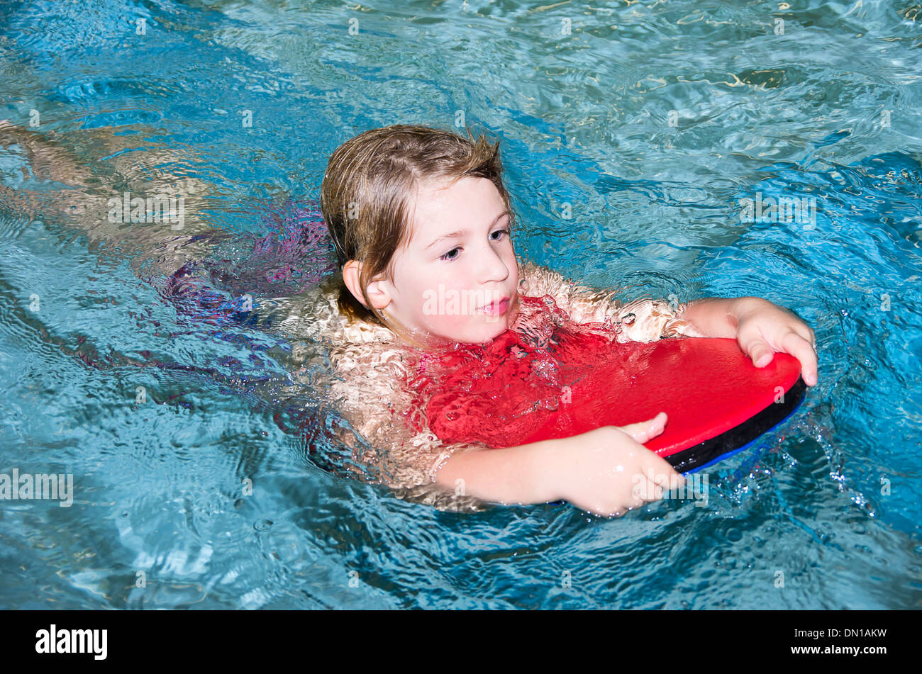 Bambine che nuota con scheda di nuoto Foto Stock