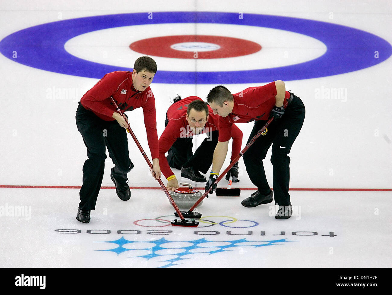 Feb 16, 2006; Torino, Peidmont, Italia; Shawn Rojeski, centro, orologi la sua consegna giovedì 16 febbraio, 2006 negli uomini il curling concorrenza durante i XX Giochi Olimpici Invernali di Torino, Italia mentre i compagni John Shuster, sinistra e Joe Polo sweep. Stati Uniti d'America battere la Svezia 10-6 nel match. Credito: Foto di W.L./San Antonio Express-News /ZUMA premere. (©) Copyright 2006 by San Antonio Foto Stock