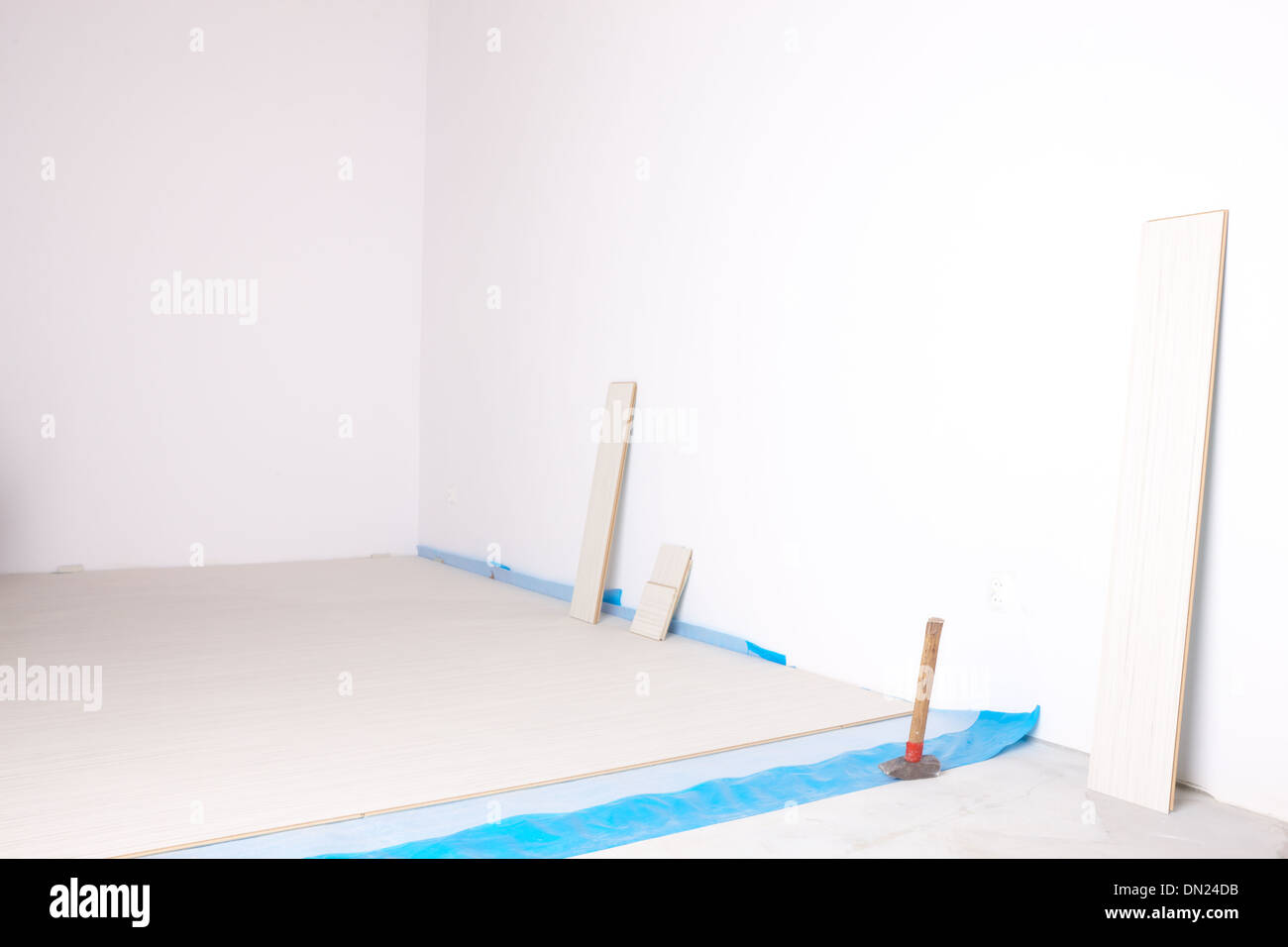 Stanza vuota durante i lavori di ristrutturazione con pavimenti in laminato, pareti whithe e lavoratori strumenti Foto Stock
