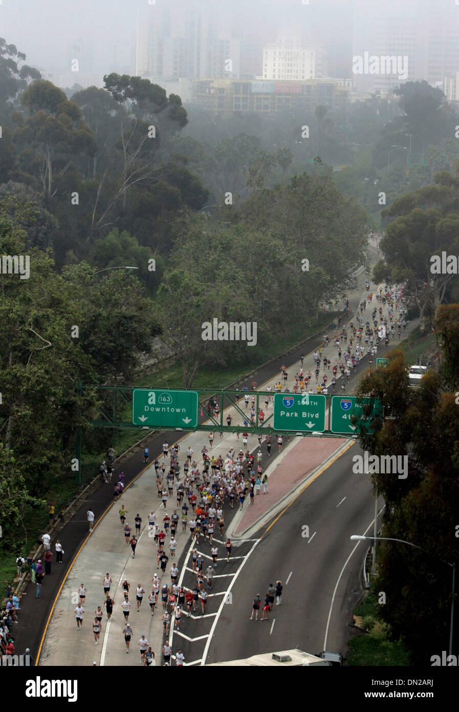 Jun 04, 2006; San Diego, CA, Stati Uniti d'America; ventidue mila corridori scoppiare attraverso la nebbia di domenica mattina per iniziare questo anno di Rock 'n' Roll Marathon. Come hanno progredito verso nord sulla 163 Freeway, la nebbia leggermente sollevata, sufficiente a dimostrare di sommità di edifici del centro. Credito: Foto di Peggy Peattie/SDU-T/ZUMA premere. (©) Copyright 2006 by SDU-T Foto Stock