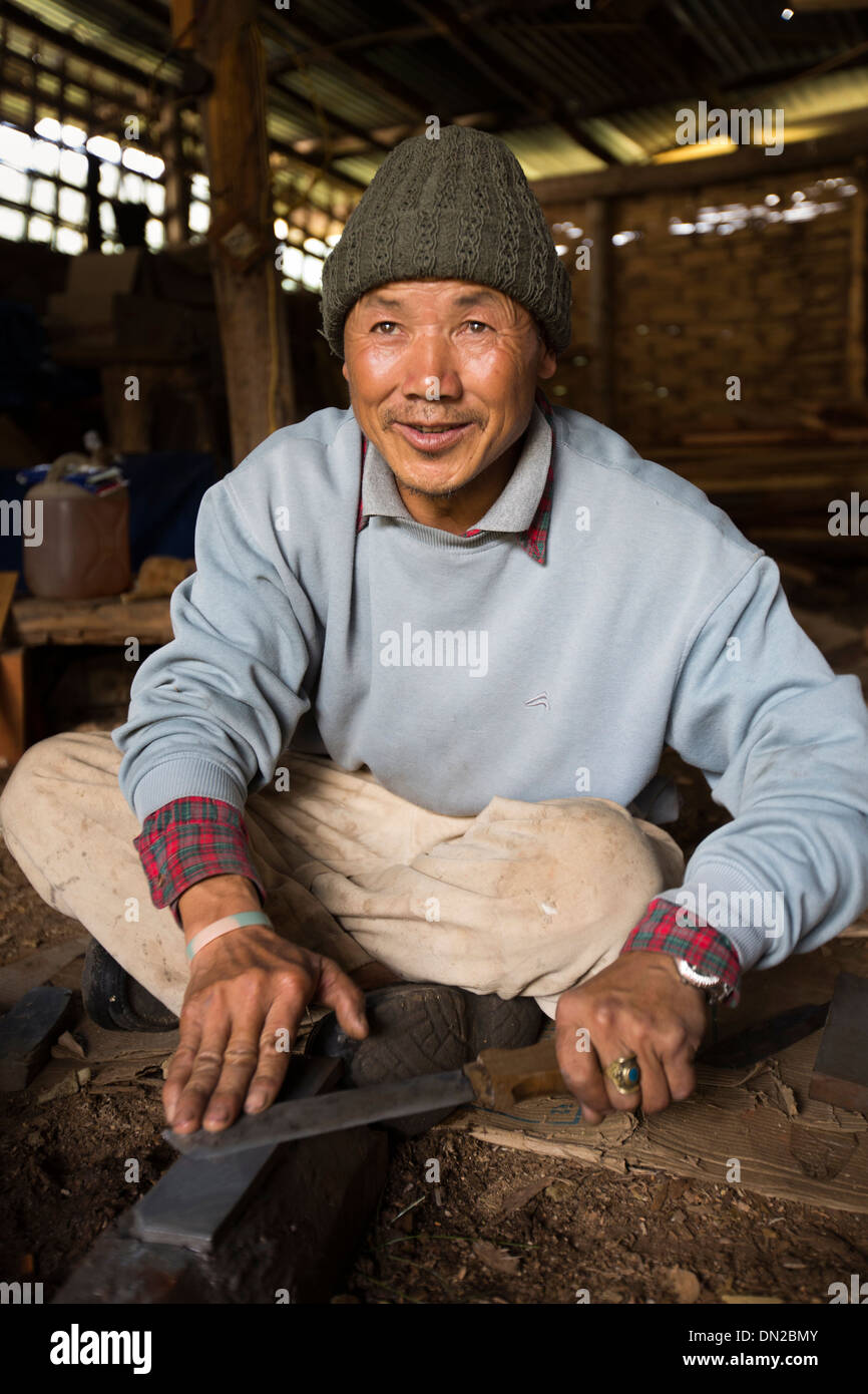 Il Bhutan, Bumthang Kurjey Lhakang monastero, artigiano scalpello di affilatura su pietra ad olio Foto Stock