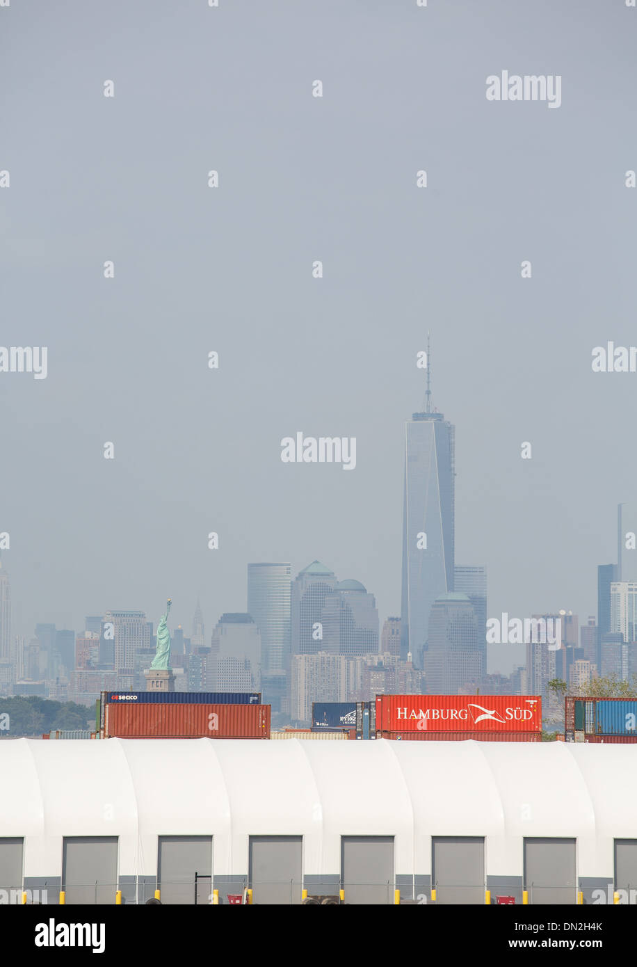 Un terminal merci nel porto di New York con la Statua della Libertà e sullo skyline in background Foto Stock