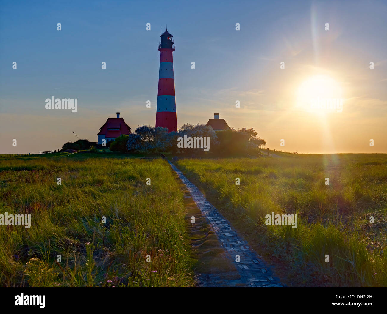 Faro Westerheversand in controluce, penisola di Eiderstedt, Frisia settentrionale, Schleswig-Holstein, Germania Foto Stock