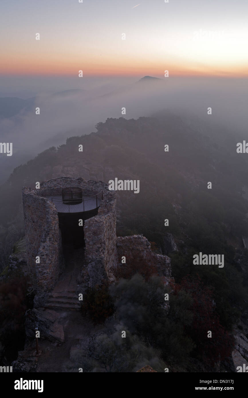 Sunrise oltre il Castillo de Monfrague con laminazione nebbia sulle colline Foto Stock