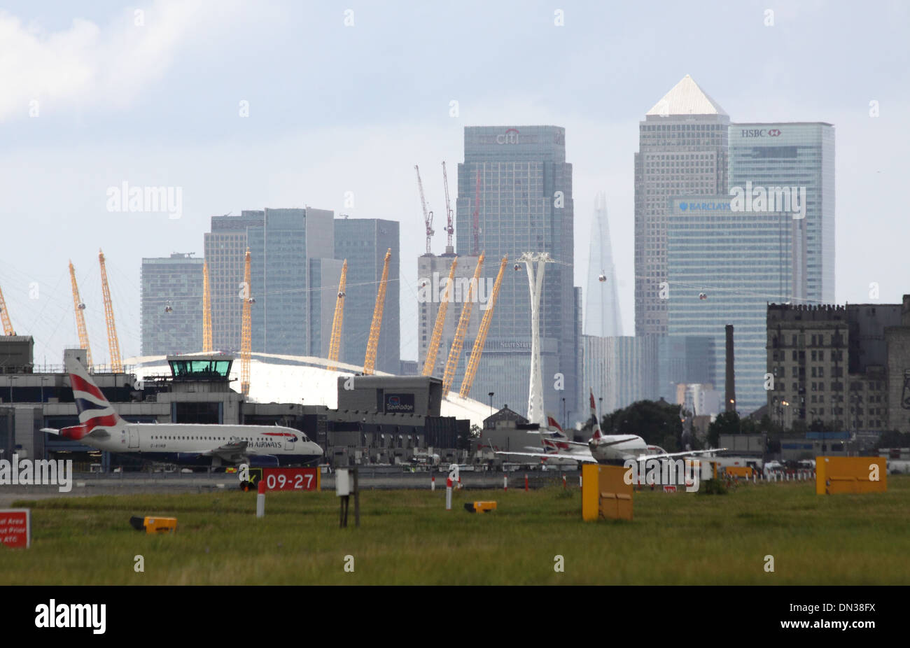 Il City Airport. Zoom a tenuta con la cupola e il quartiere finanziario di Haze di calore Foto Stock