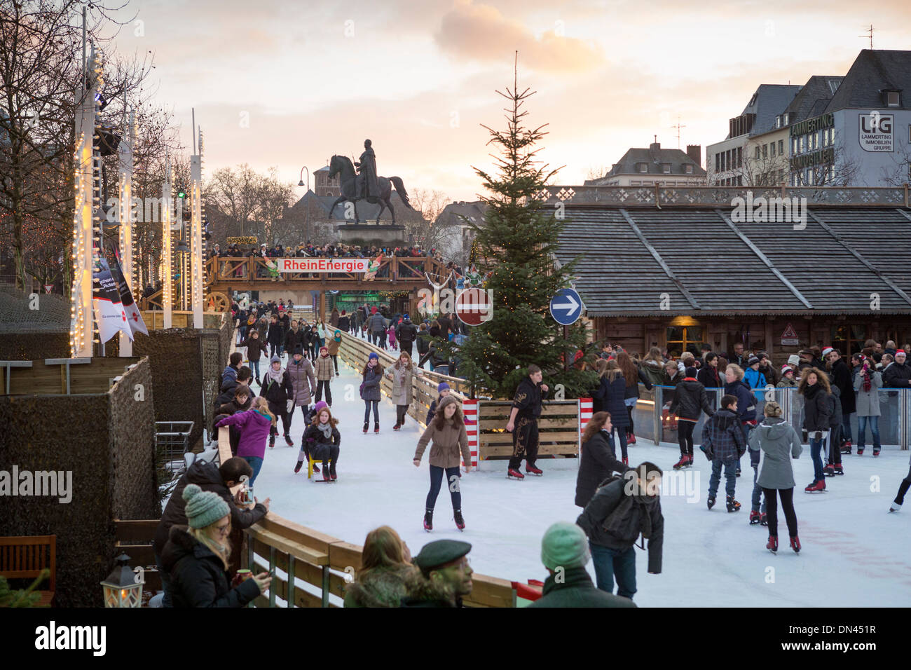 Germania Mercatino di Natale di Colonia pattinaggio su ghiaccio con il pattinaggio persone all'Altstadt (con un banner da Rheinenergie) Foto Stock