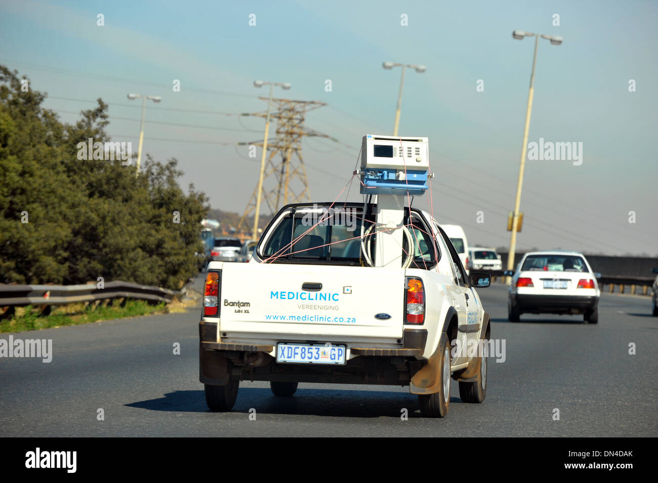 Un carrello di prelievo che trasportano un medico unità della macchina lungo un sudafricano autostrada. Foto Stock