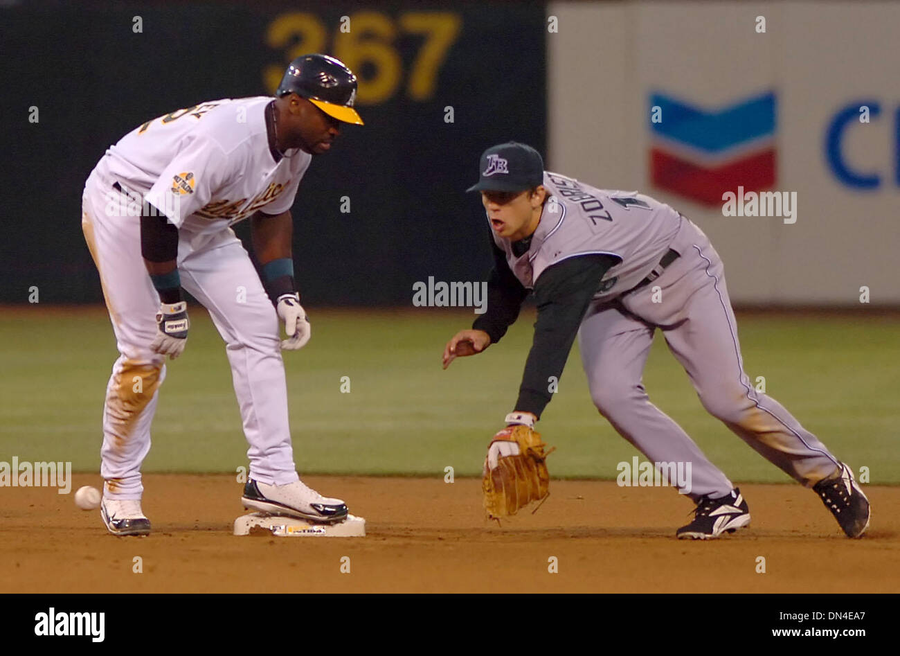 Aug 11, 2006; Oakland, CA, Stati Uniti d'America; Oakland Athletics Milton Bradley, #22, è sicuro a seconda base come Tampa Bay Devil Ray di Ben Zobrist, #18 raggiunge per la palla nel quarto inning del loro gioco su Venerdì, 11 agosto 2006 a McAfee Coliseum di Oakland, California Bradley è collegata per una singola ma arrivato alla seconda base su un errore. Credito: Foto di Jose Carlos Fajardo/Contra Costa Ti Foto Stock