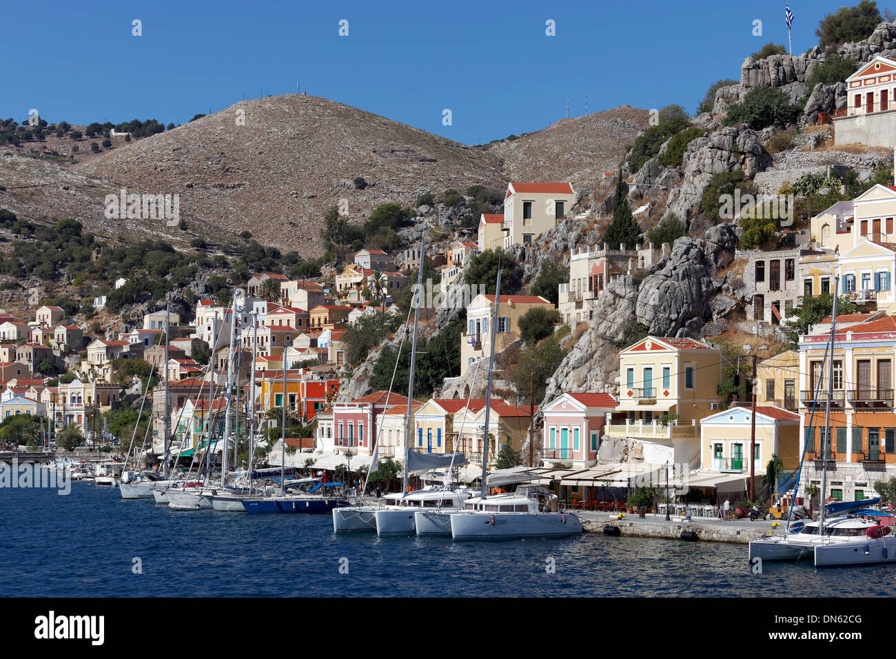 Il porto della città di Symi con pittoresche case in stile neo-classico, Symi, Symi Island, Dodecaneso, Grecia Foto Stock