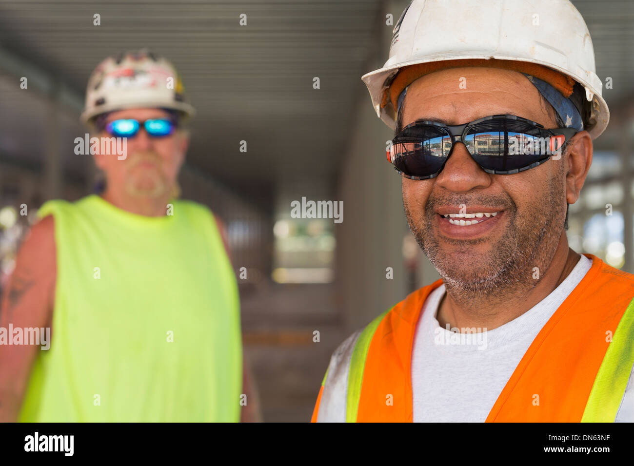 Lavoratori sorridente al sito in costruzione Foto Stock