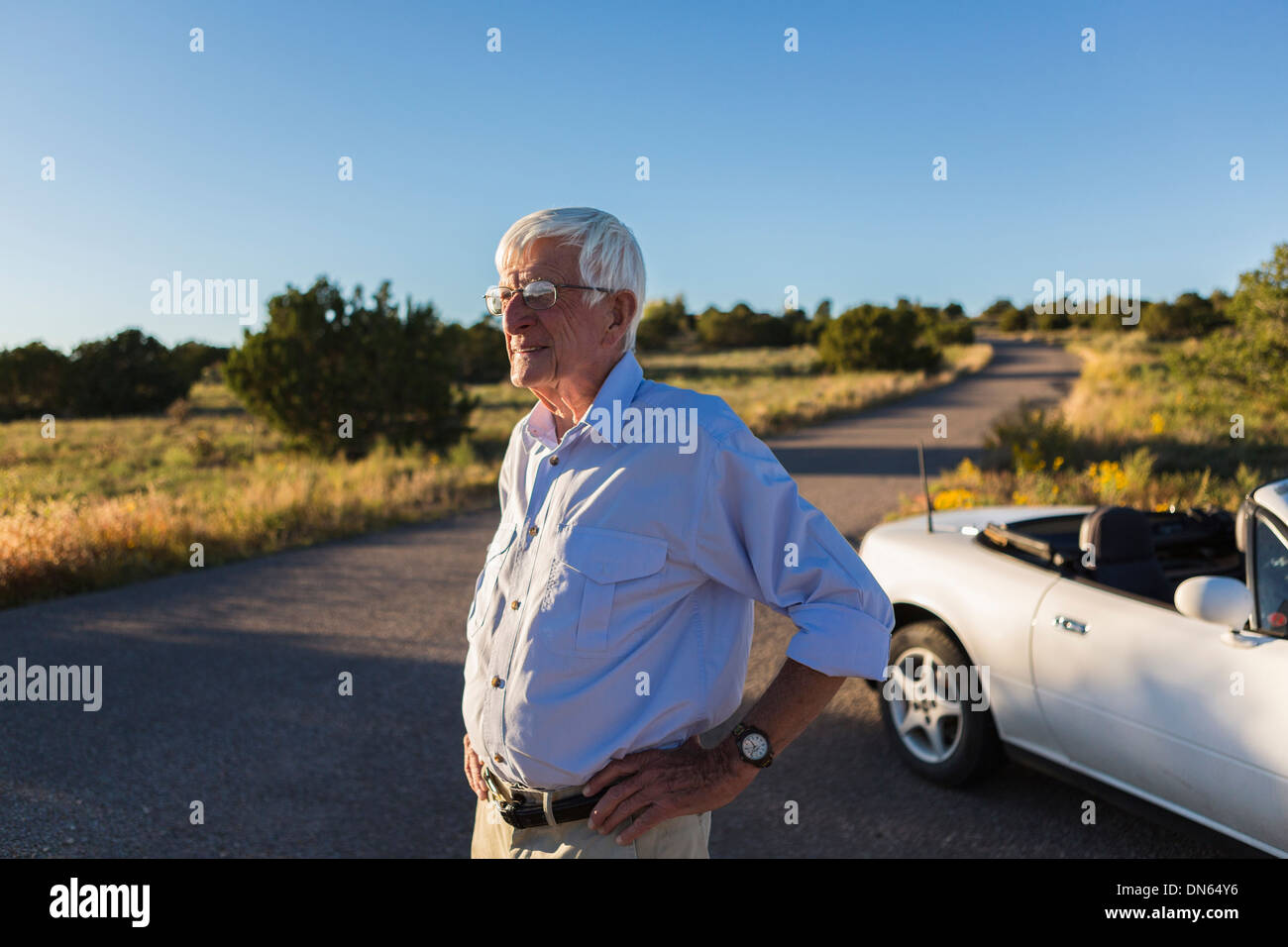 Senior uomo caucasico permanente sulla strada rurale Foto Stock