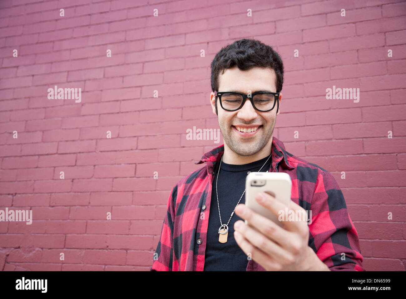 Uomo ispanico tramite telefono cellulare all'aperto Foto Stock