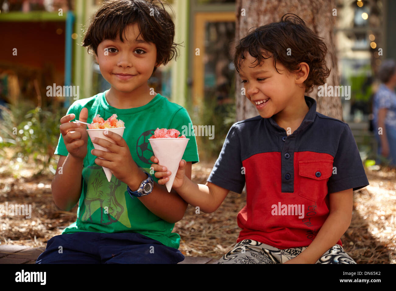 Razza mista ragazzi a mangiare il gelato all'aperto Foto Stock