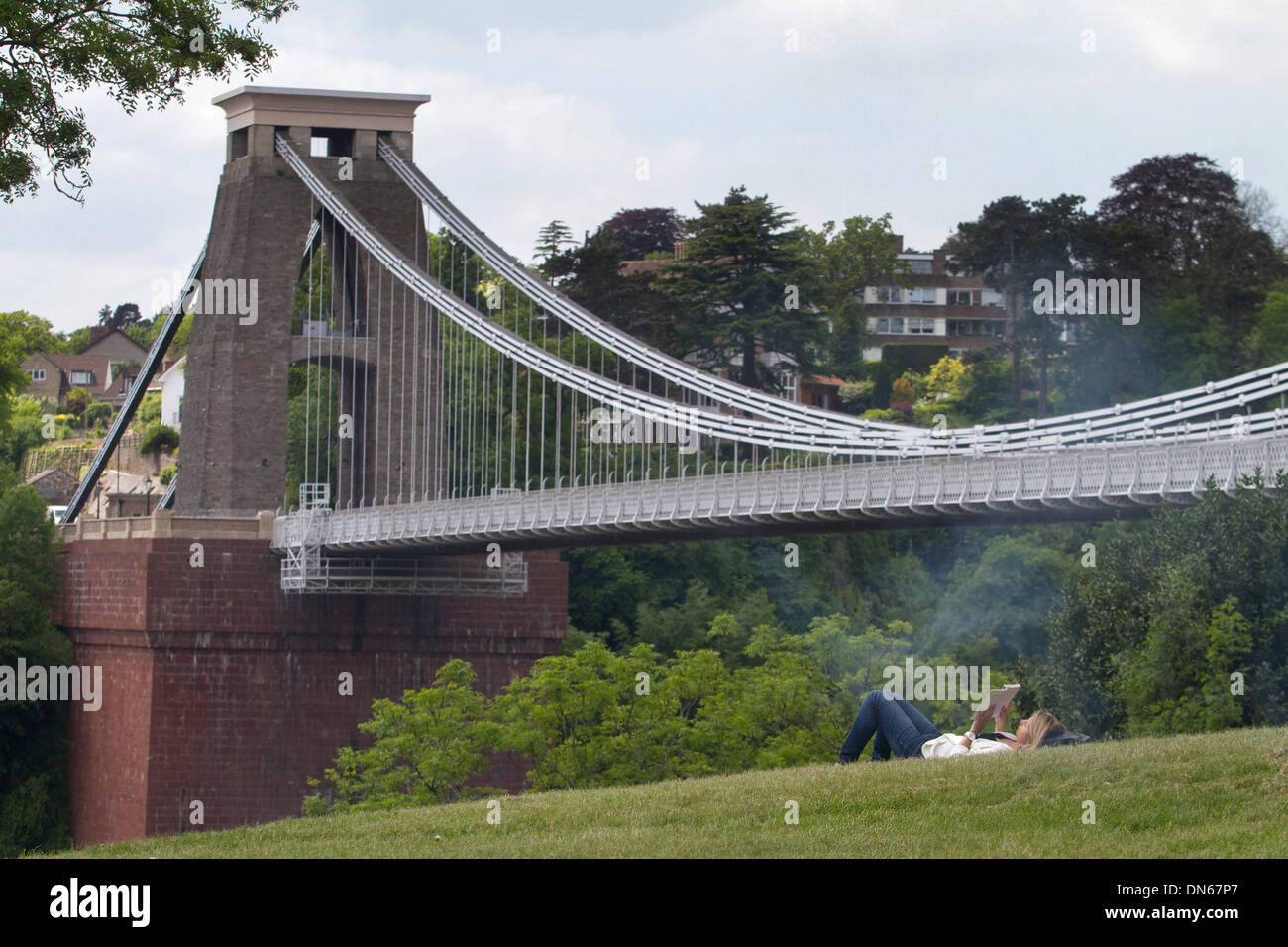 Una donna si legge nella parte anteriore del ponte sospeso di Clifton, Bristol, come tempo caldo continua in tutto il Regno Unito. 03 giugno 2013. Foto Stock