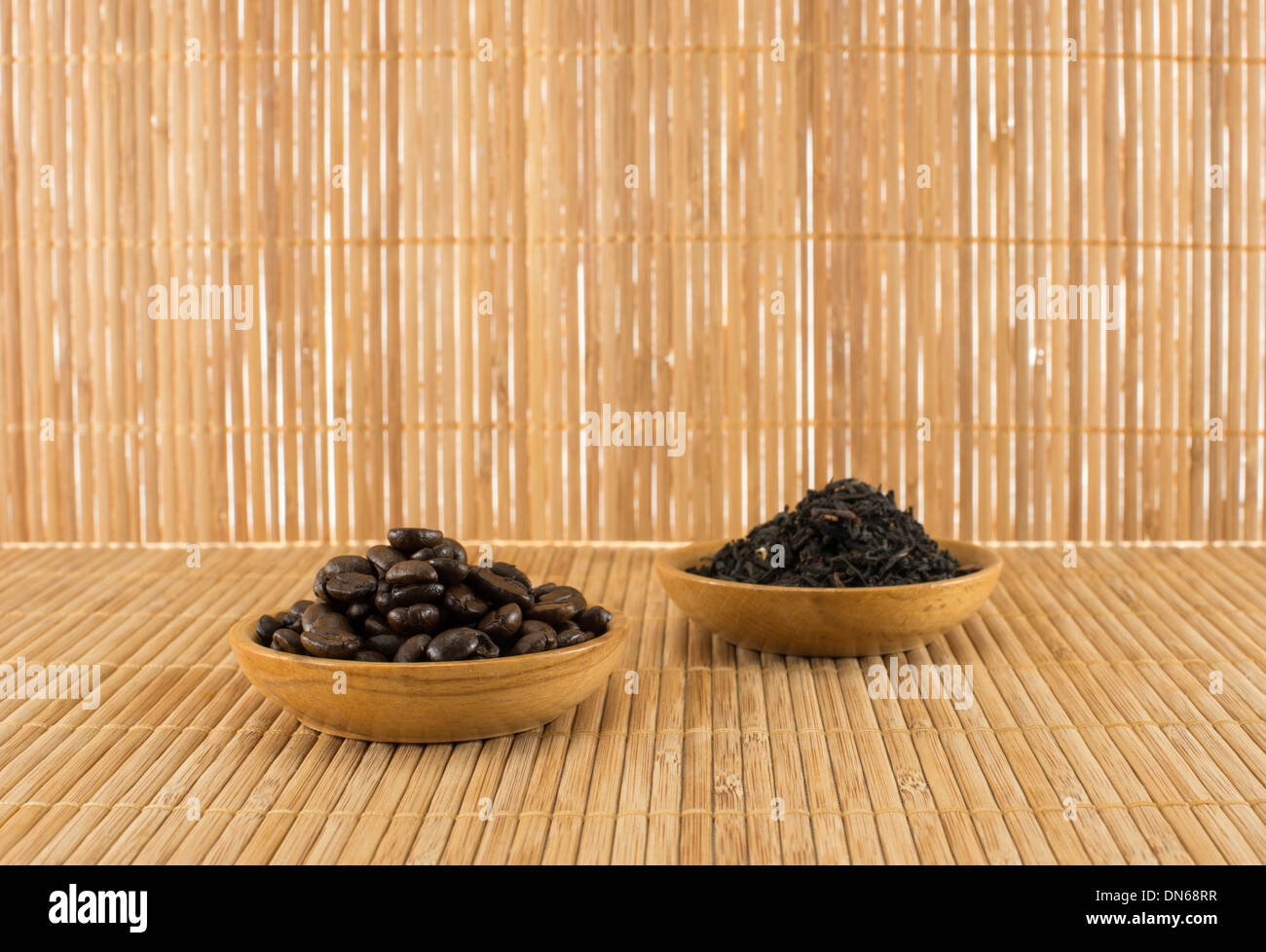 I chicchi di caffè e foglie di tè sulla tabella di bambù Foto Stock