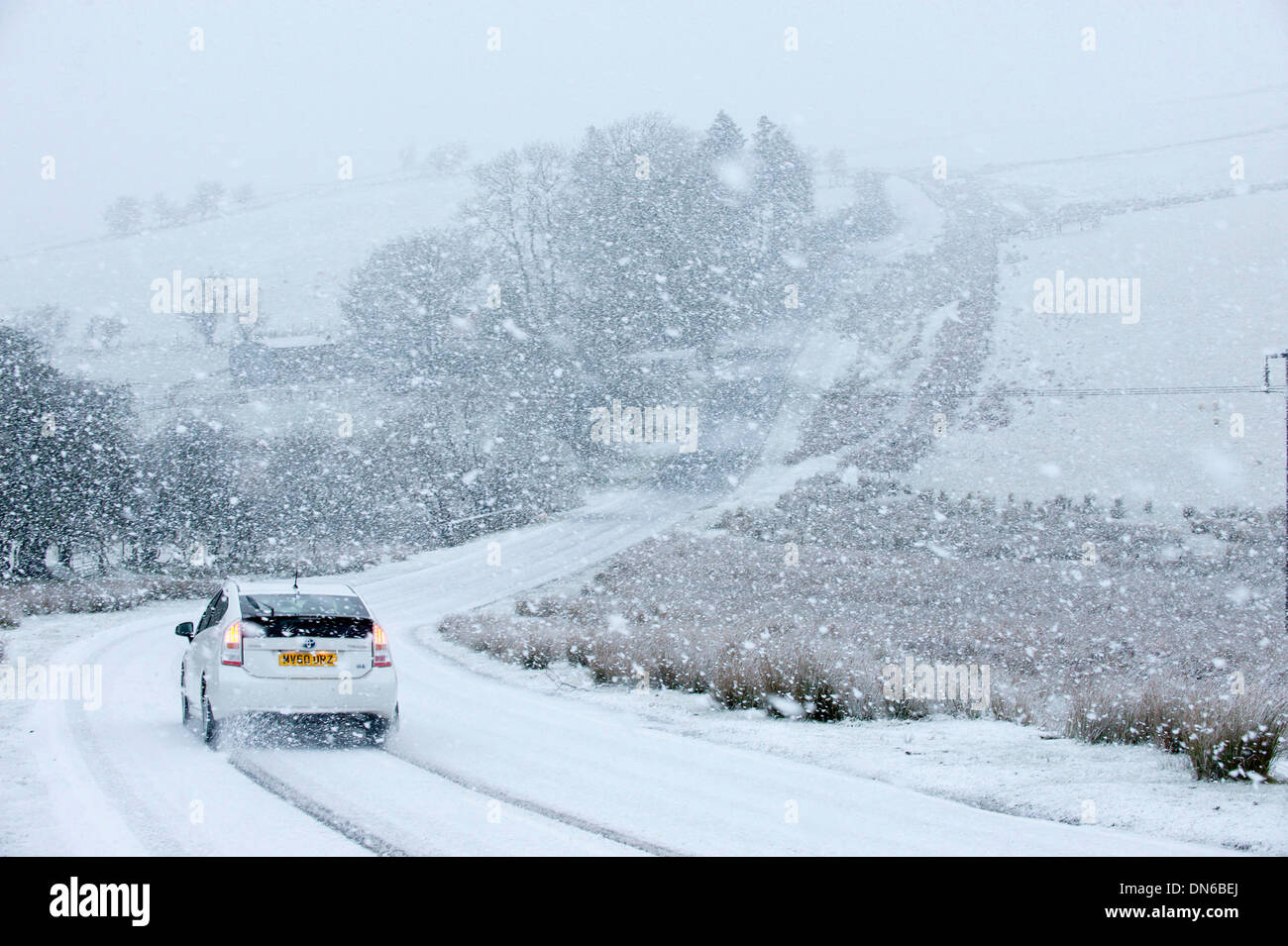 Gamma Epynt, Cambrian Mountains, il Galles, Powys, Regno Unito. 19 dicembre 2013. Gli automobilisti sono stati colti di sorpresa quando il tempo è andato da pioggia grandine di neve pesante nello spazio di 5 minuti su terra alta in Galles Centrale. Vi è stato il nevischio a livelli inferiori Credito: Graham M. Lawrence/Alamy Live News Foto Stock