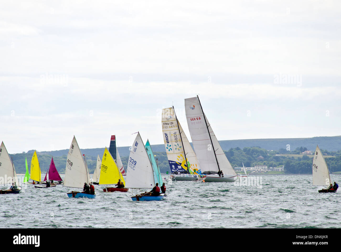 Fastnet yacht race 2013. Barca da regata sailing giù il Solent dopo la partenza da Cowes. Due barche di incollamento attraverso squallide gara Foto Stock