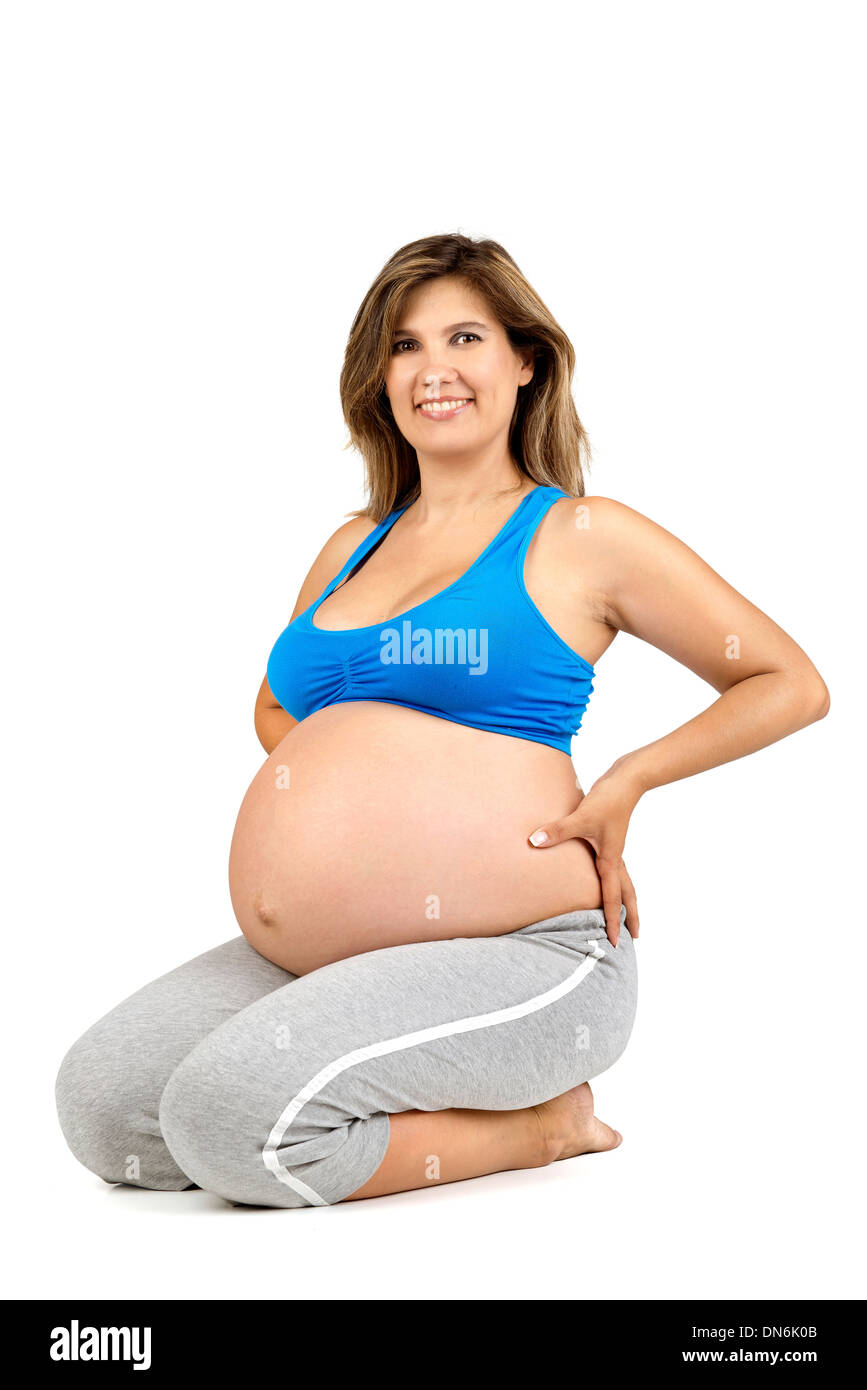 Bella donna incinta in posa di abbigliamento fitness Foto Stock