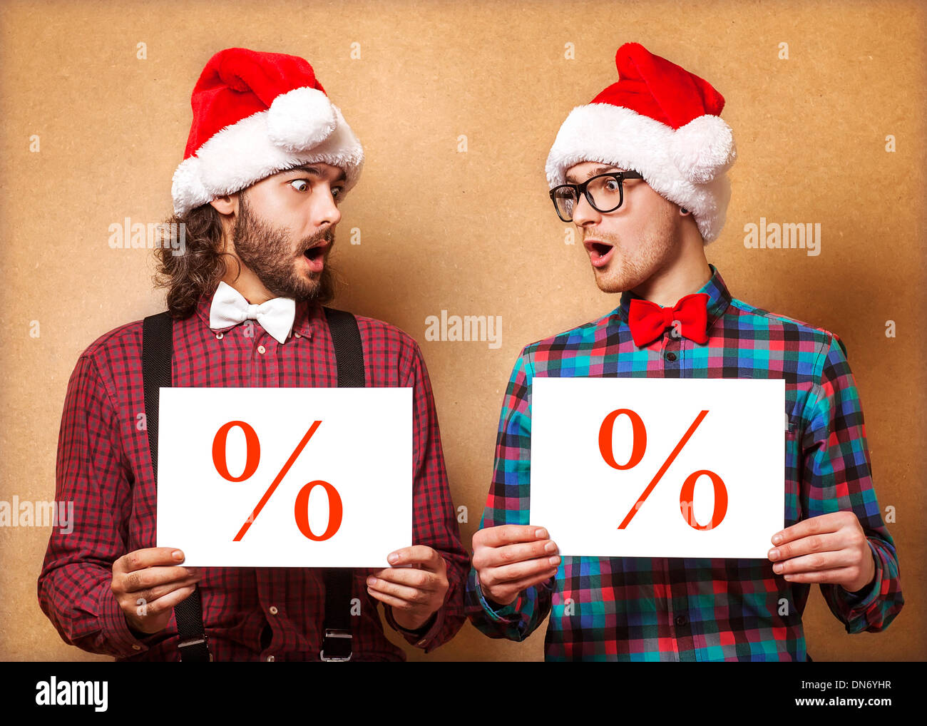Natale, X-mas, persone, pubblicità, vendita concetto - happy due uomo in santa helper hat con vuoto scheda bianca. Hipster stile. Foto Stock