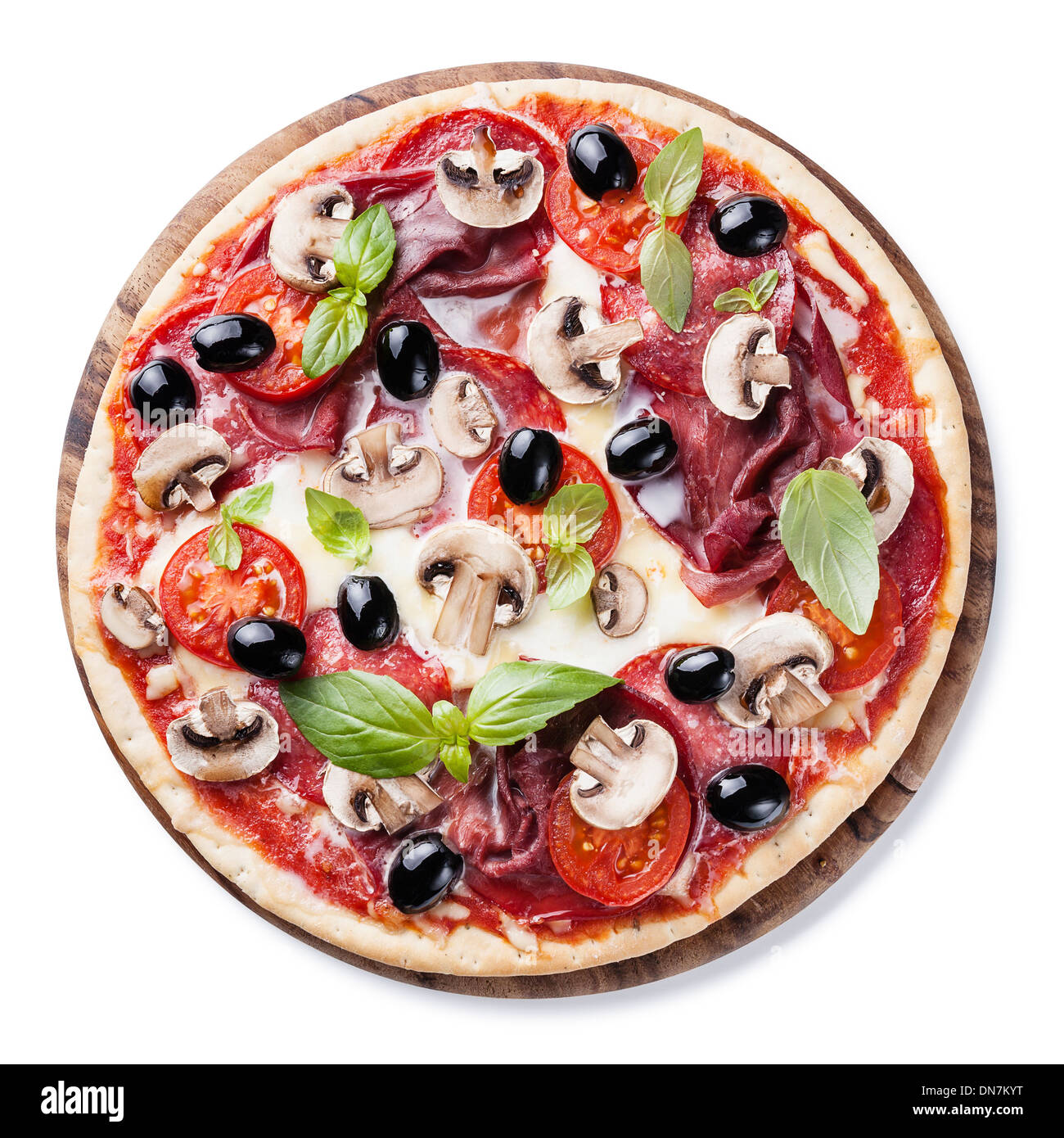 La pizza italiana con salumi, funghi, olive e le foglie di basilico su sfondo bianco Foto Stock