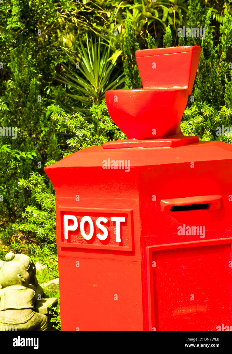 Cassetta postale di rosso. È stato collocato nel giardino. Foto Stock