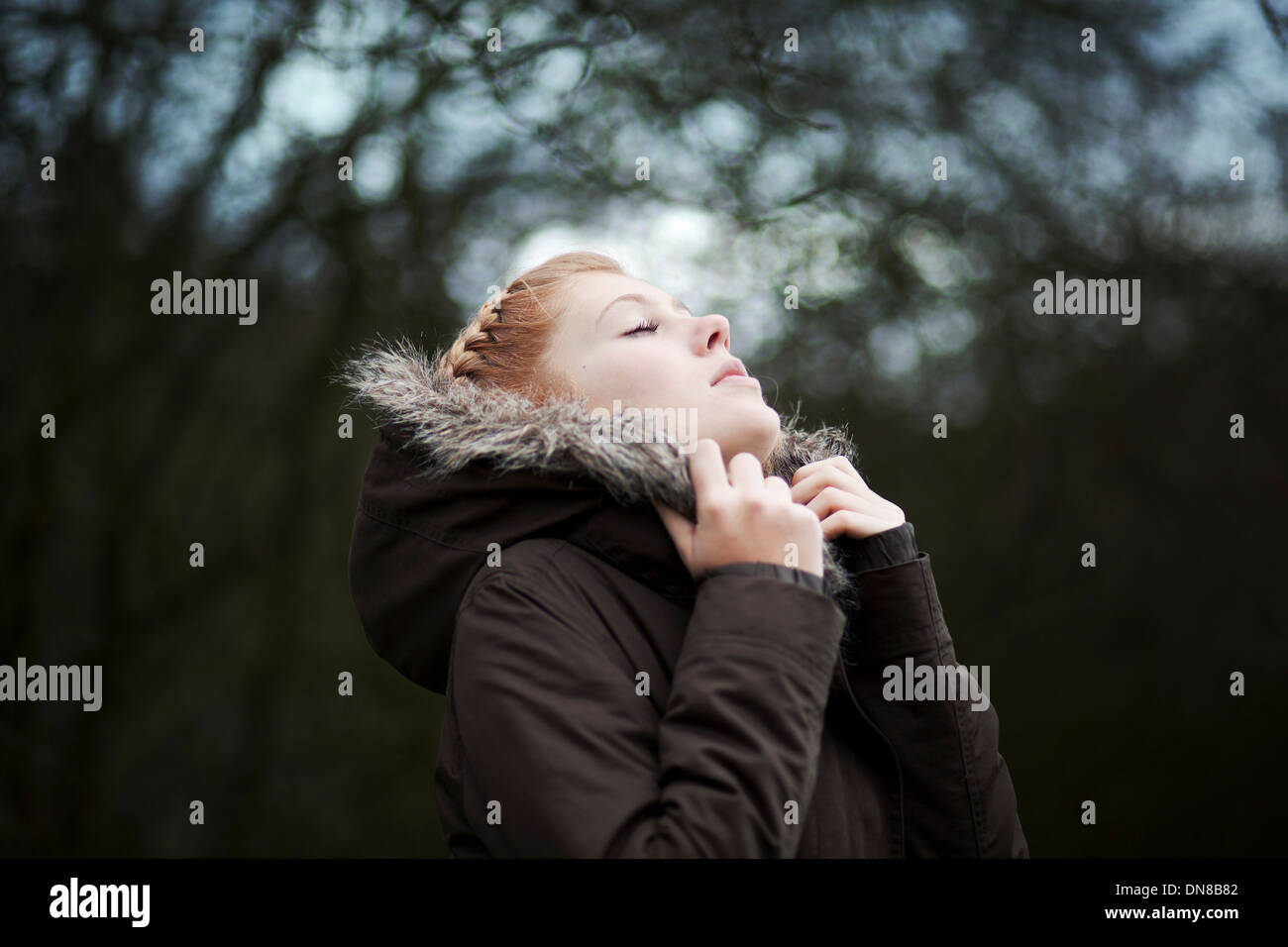 Donna con gli occhi chiusi coccola in giacca invernale Foto Stock