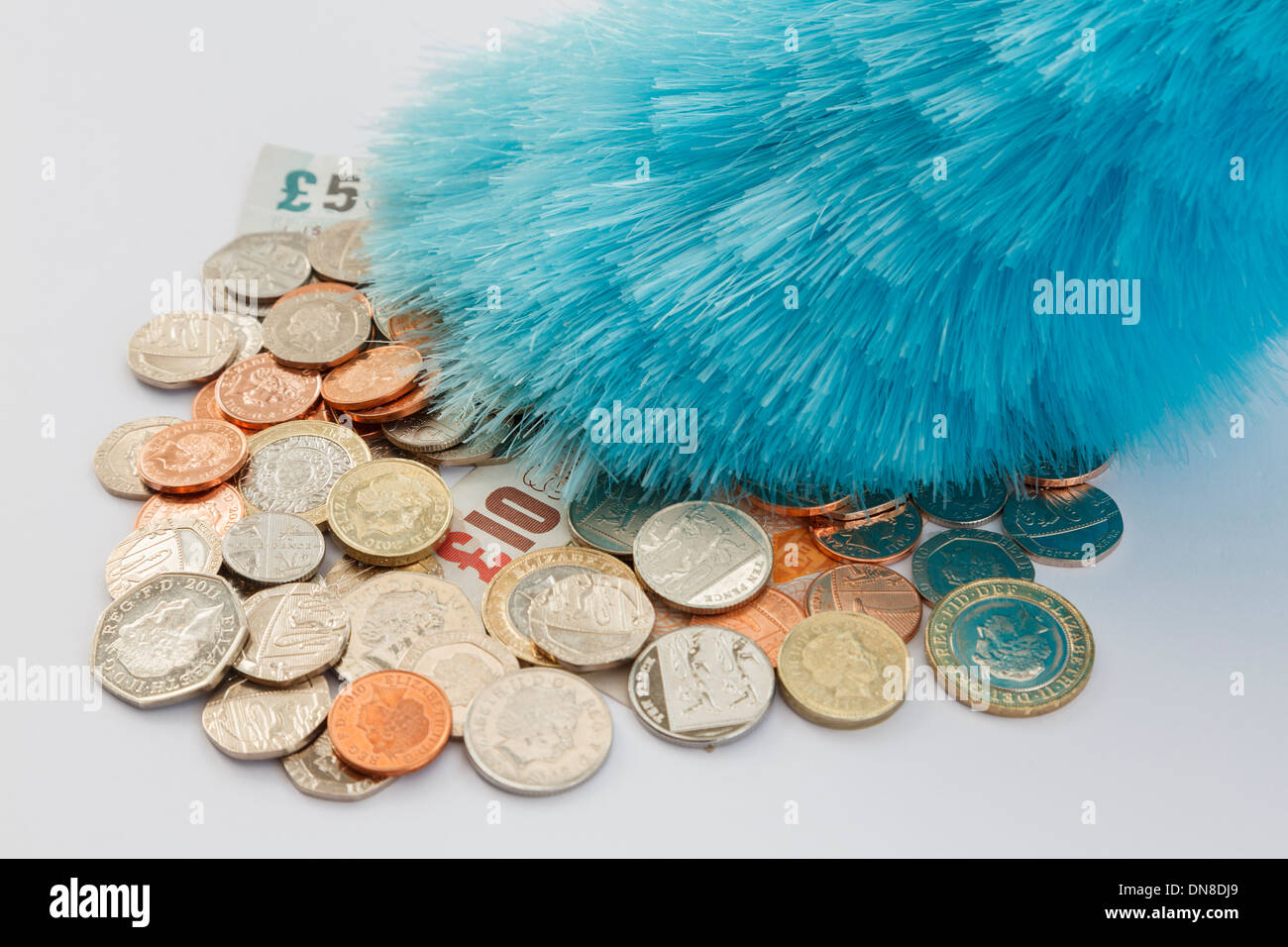 Un piumino spolvero un mucchio di soldi sterling delle monete e delle banconote. Inghilterra, Regno Unito, Gran Bretagna Foto Stock