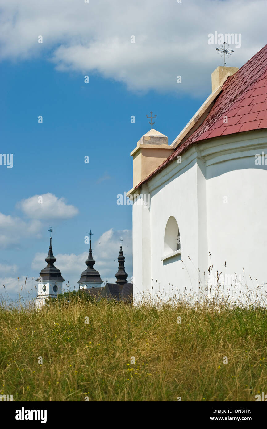 Il San Floriano Cappella in Goniadz, Voivodato Podlaskie, Polonia. Sullo sfondo le tre torri del sant Agnese chiesa. Foto Stock