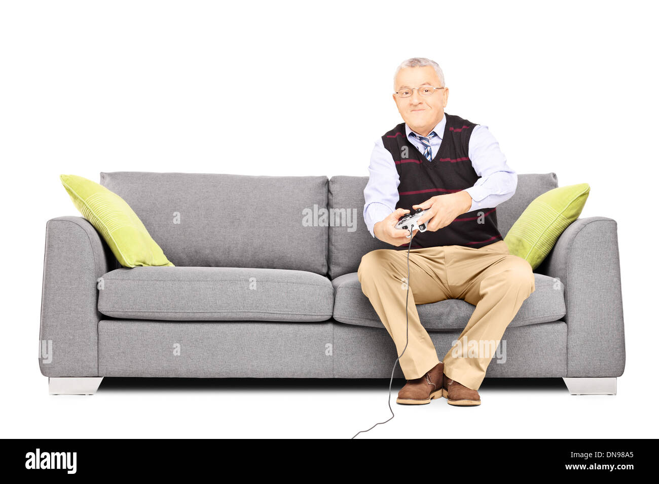Senior uomo seduto su un divano e la riproduzione di video giochi Foto Stock
