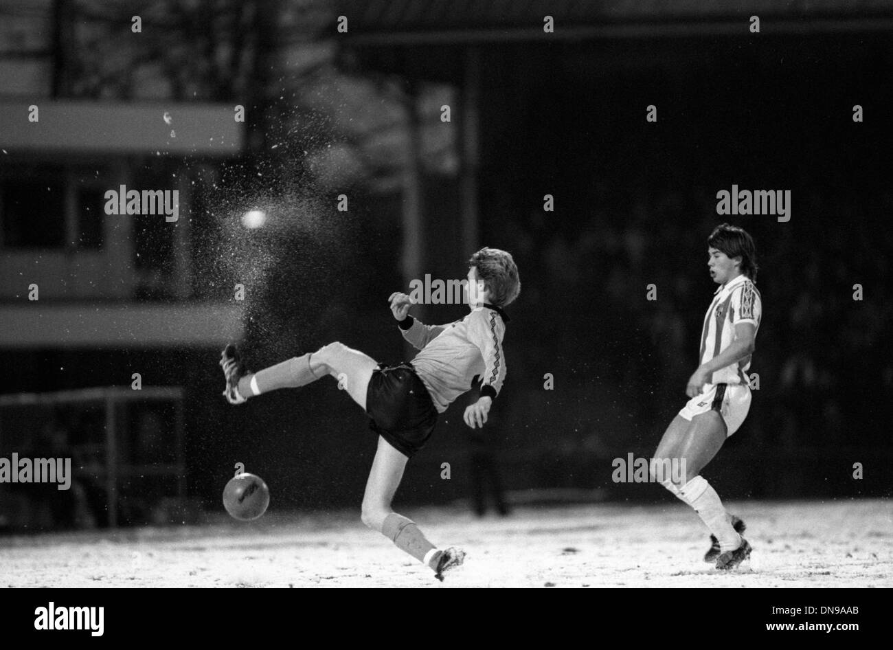 Wolverhampton Wanderers calciatore Mick Hollifield sembra aver dato dei calci a una palla di neve guardato Adrian Heath di Stoke City 29/11/80 Foto Stock