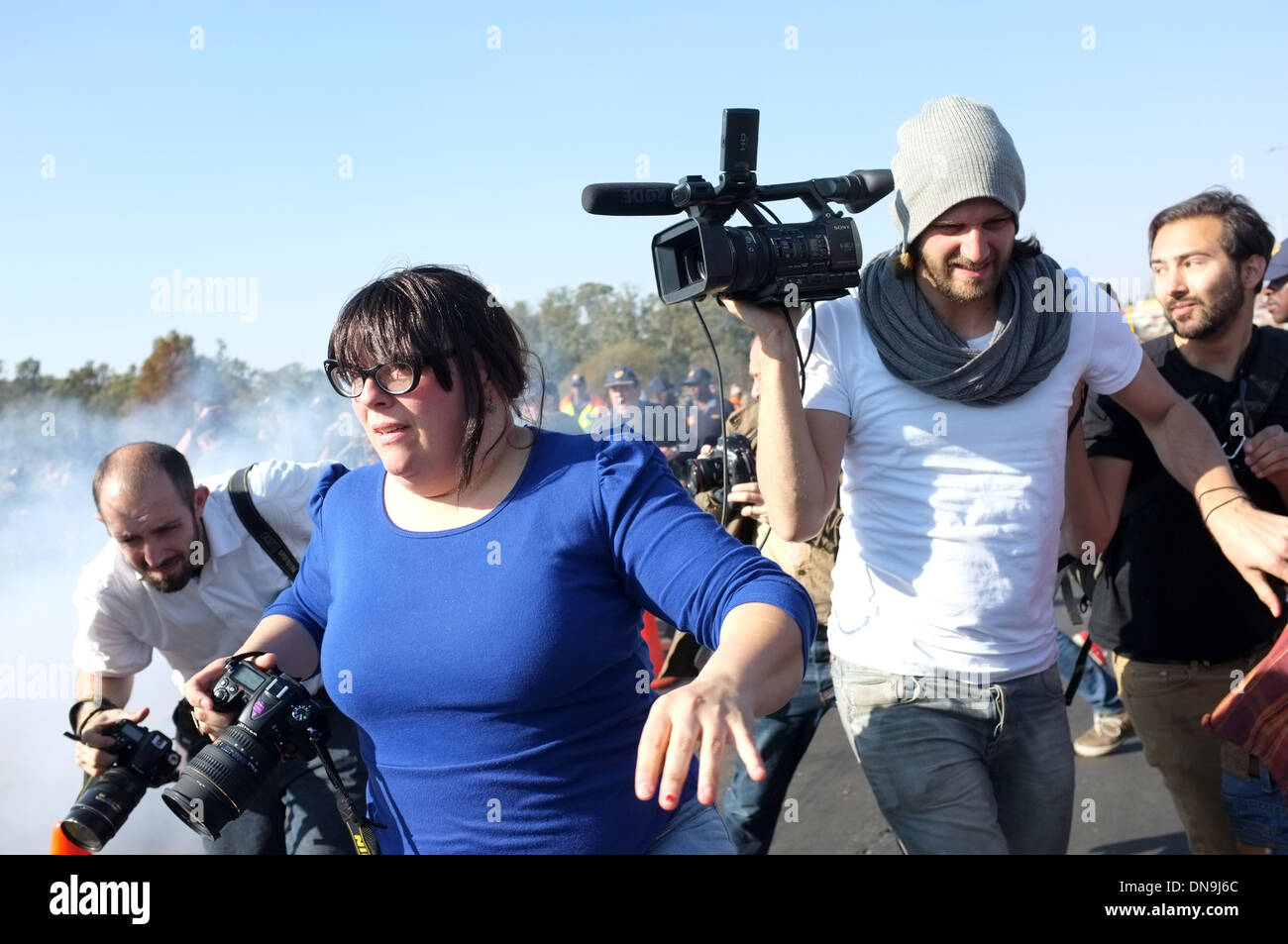 I giornalisti scappare da granate fumogene a South African protesta di Soweto. Foto Stock