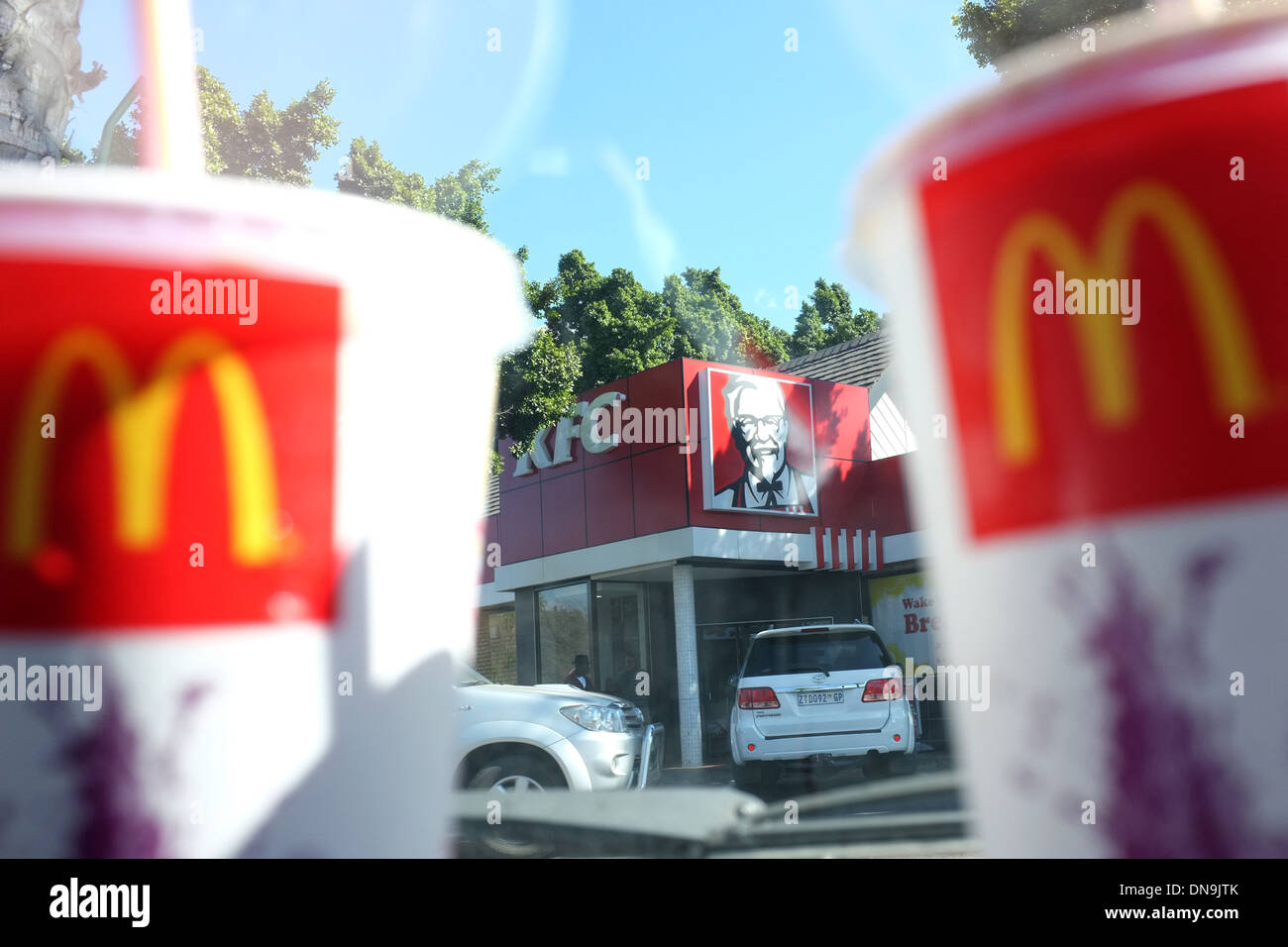 McDonalds loghi per contenitori di bevande con un KFC store in background. Foto Stock