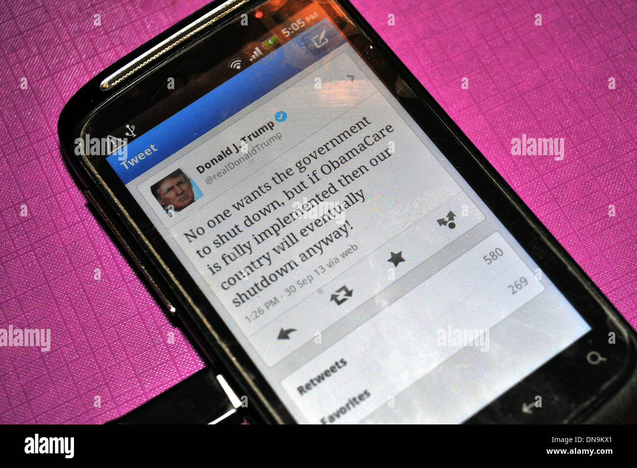 Donald Trump tweet per quanto riguarda Obamacare su una schermata telefono presa prima dell'arresto del governo nel 2013. Foto Stock