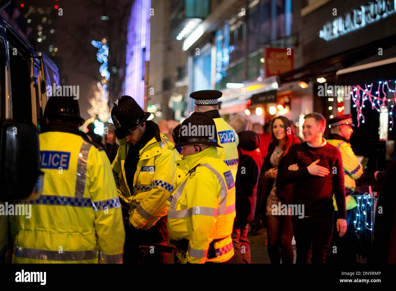 Manchester, Regno Unito. Xx Dicembre, 2013. La polizia e gli altri servizi di emergenza sono per le strade nella notte soprannominato "annuncio venerdì" - l'ultimo venerdì prima di Natale. Il giorno è tradizionalmente una notte quando molti dipendenti della società godono della reciproca compagnia con l'aiuto di alcol, anche se è diventato famoso per le persone di andare troppo lontano' quando le persone possono spesso finiscono per malati o feriti. Credito: Russell Hart/Alamy Live News Foto Stock