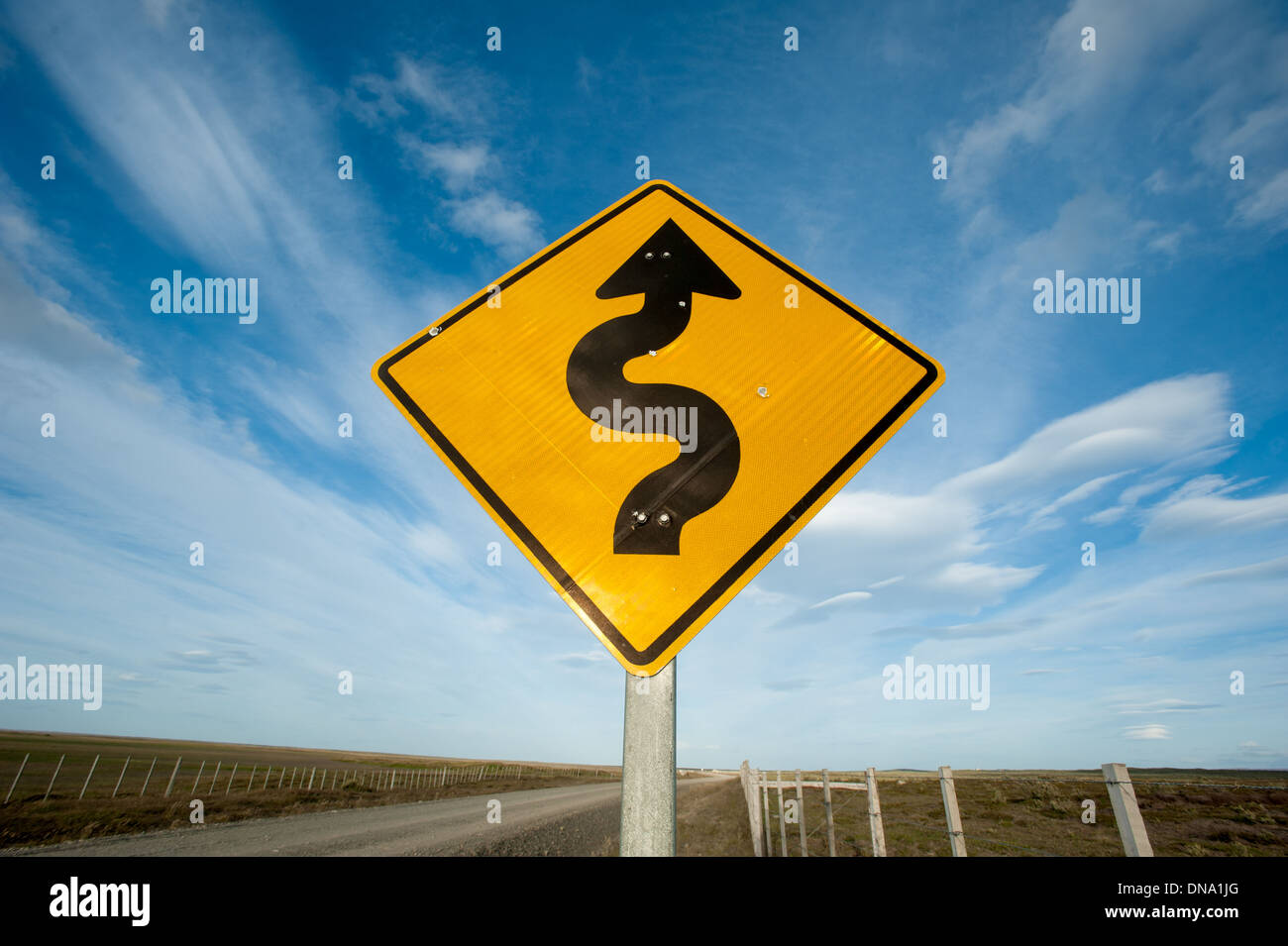 Cartello stradale che conduce curva road fino davanti, Punta Arenas in Cile Foto Stock