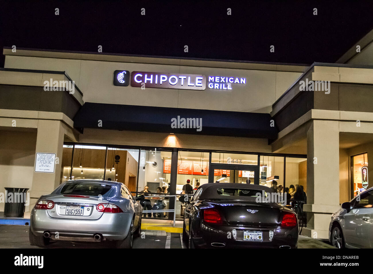 Un Chipotle Mexican Grill con una Jaguar XK e una Bentley parcheggiato di fronte a Woodland Hills in California. Foto Stock