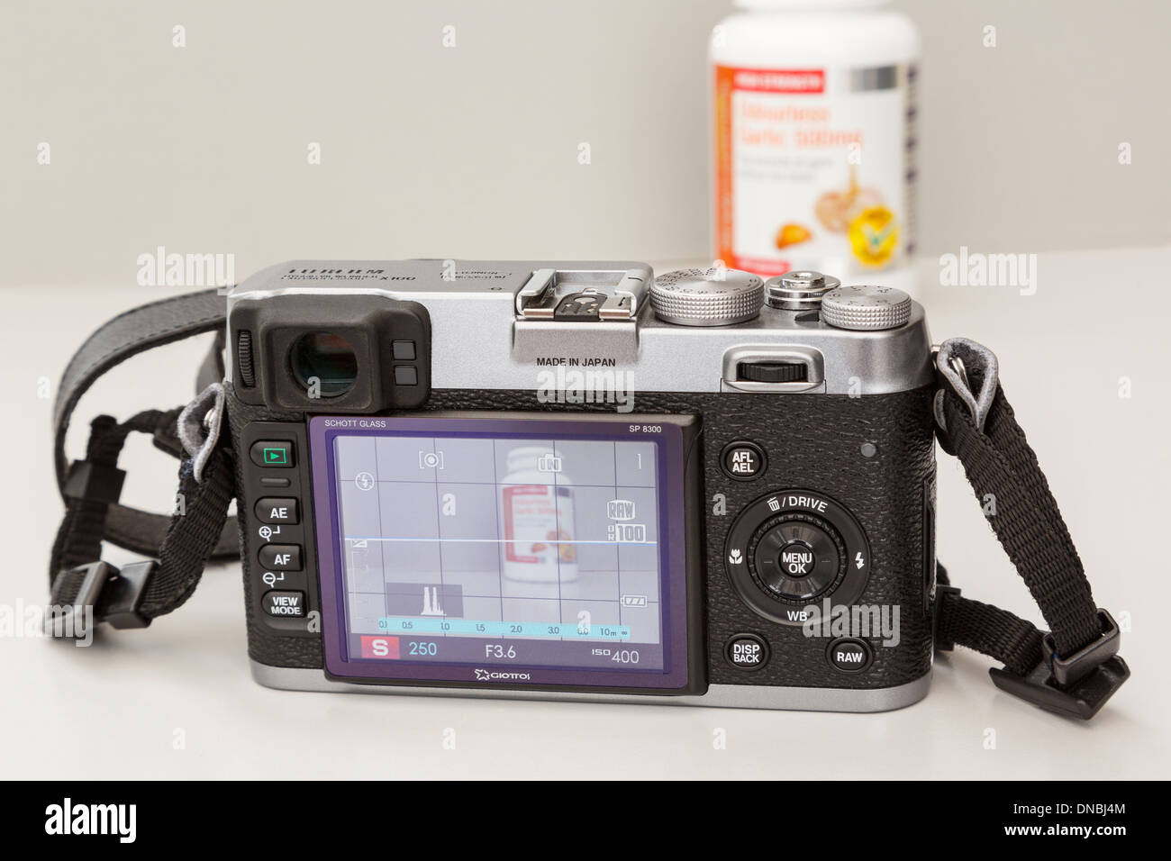 Fujifilm X100 retrò fotocamera digitale compatta con display LCD posteriore che mostra le impostazioni e modalità live view fotografando un oggetto Foto Stock
