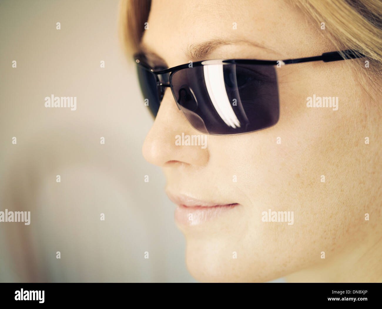 Una donna che indossa gli occhiali da sole e vista laterale Foto Stock