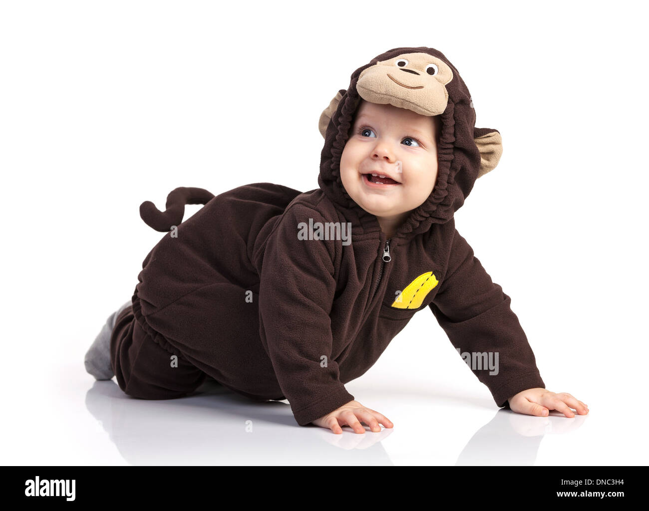 Carino baby boy in costume di scimmia cercando su sfondo bianco Foto Stock