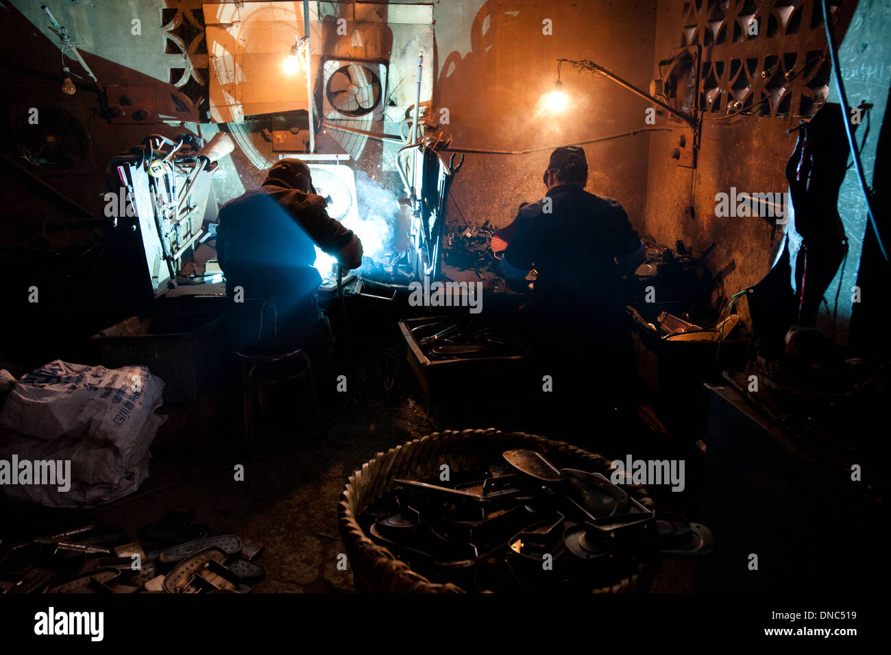 Chongqing Cina - 23 dicembre 2010: due saldatori saldare metalli in una piccola fabbrica. Foto Stock