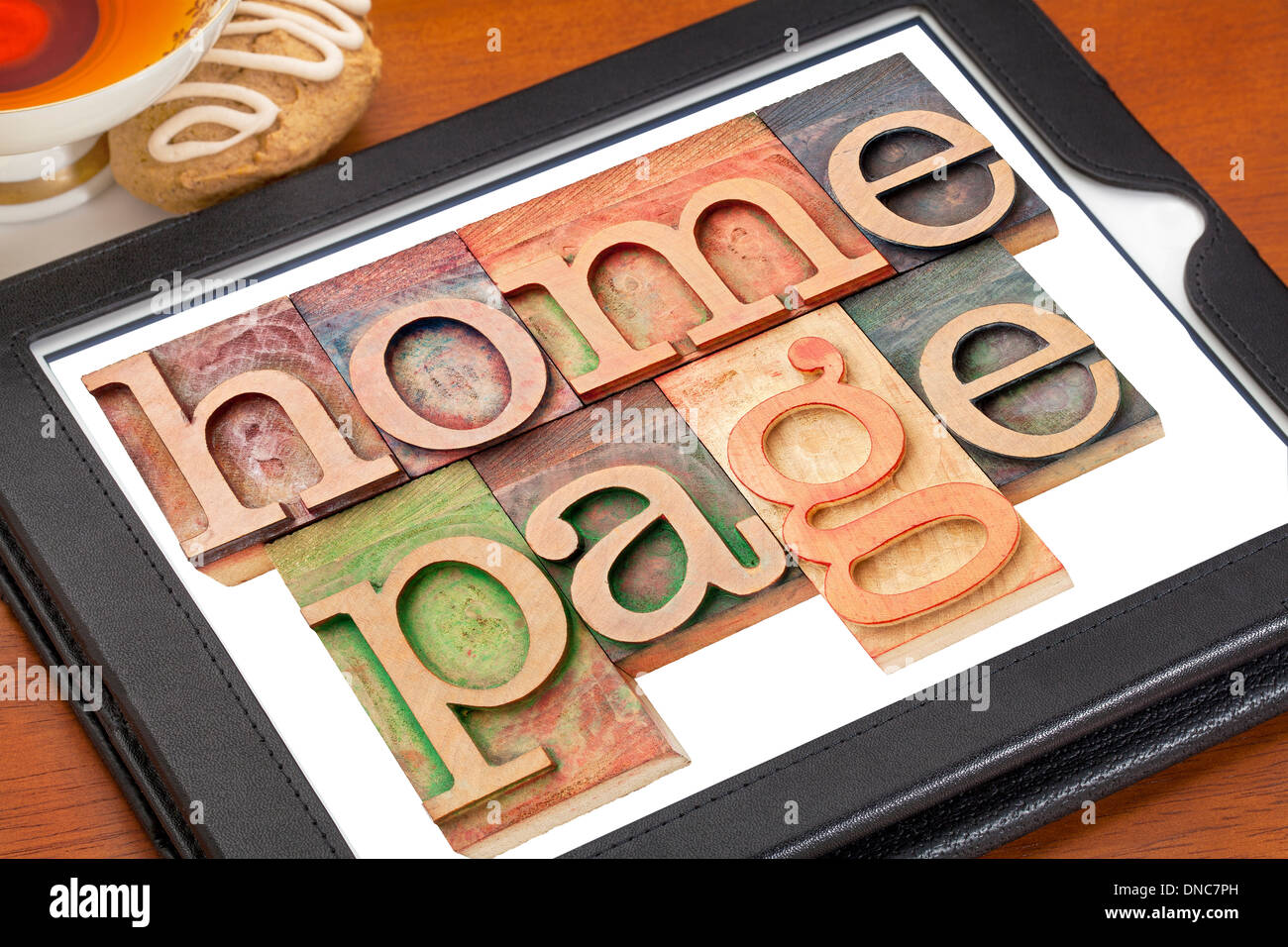 Home page - testo in tipografia tipo di legno su una tavoletta digitale con la tazza di tè Foto Stock